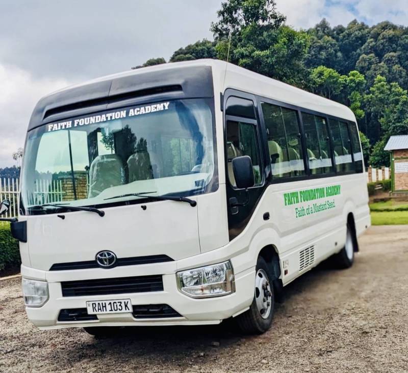 The white Faith Foundation Academy school bus parked on the school grounds