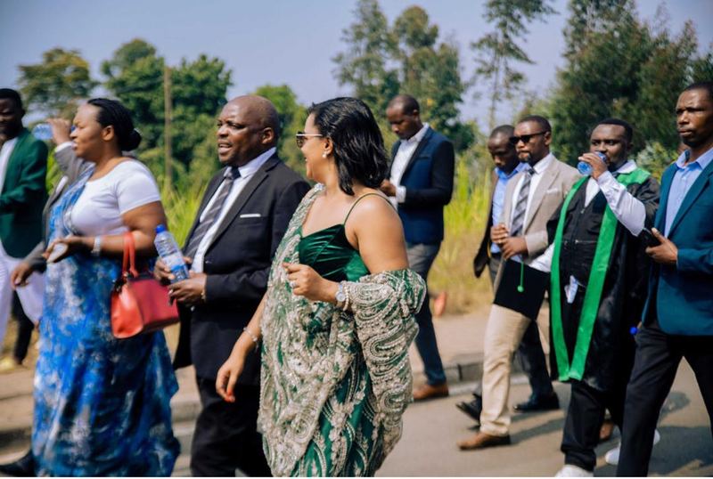 Adults in formal clothes and traditional dress walking together along a road