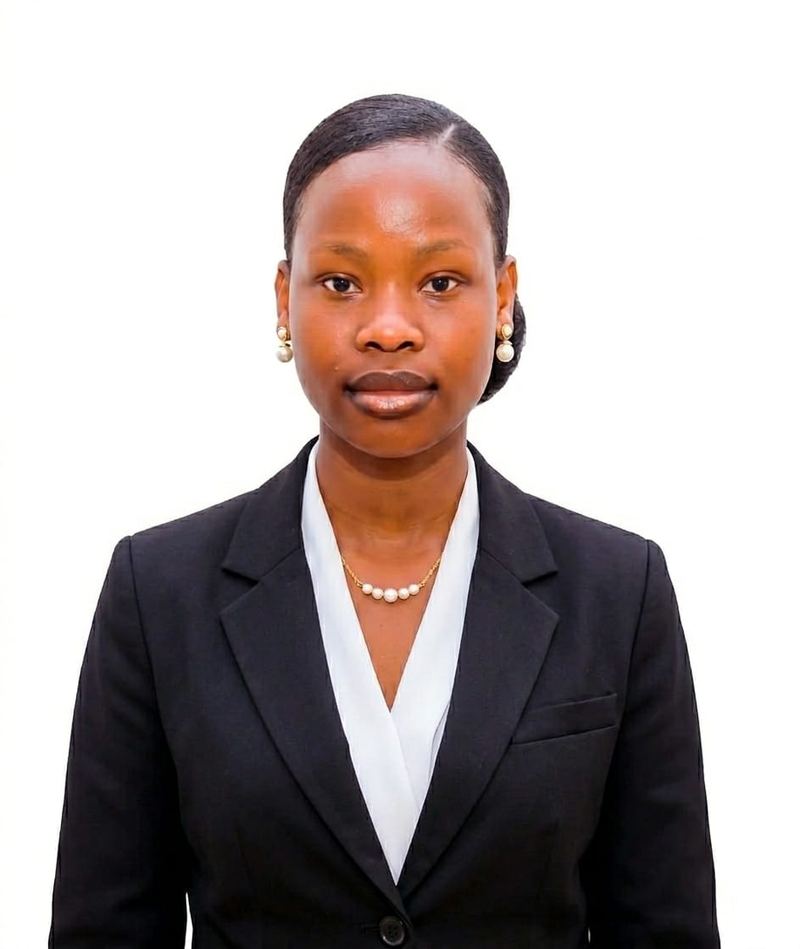 Patience Girimaya in a black blazer, white blouse and pearl necklace, against a white background